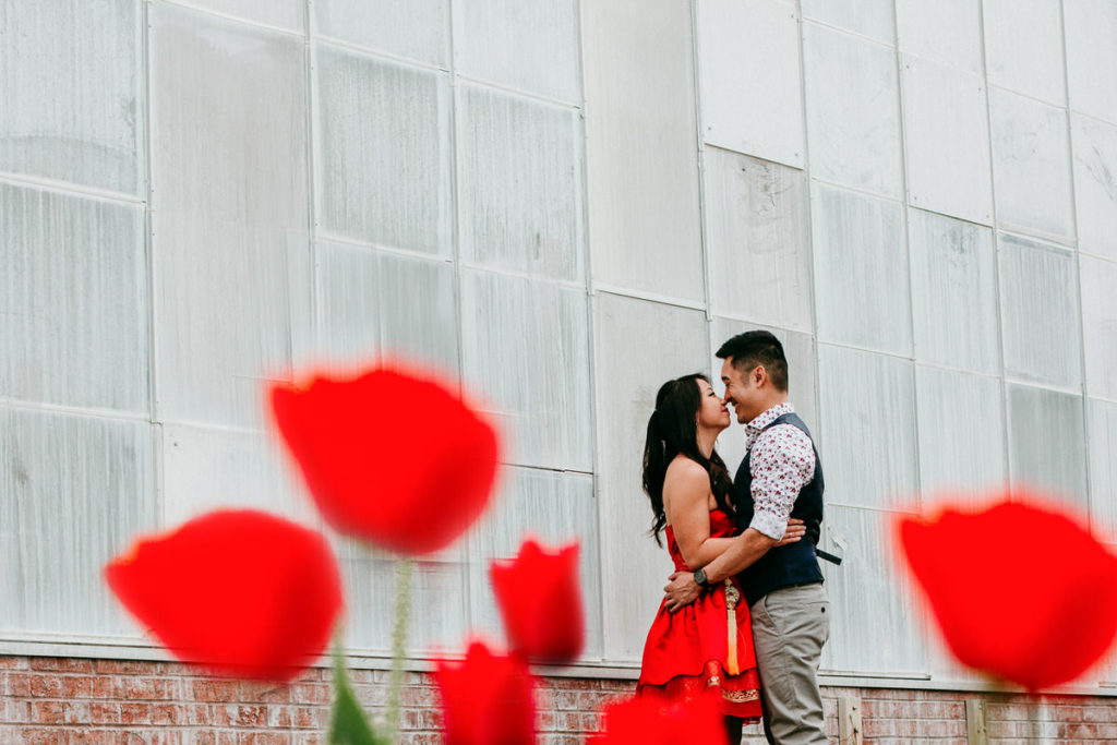 man and woman hugging and about to kiss with roses in front of them