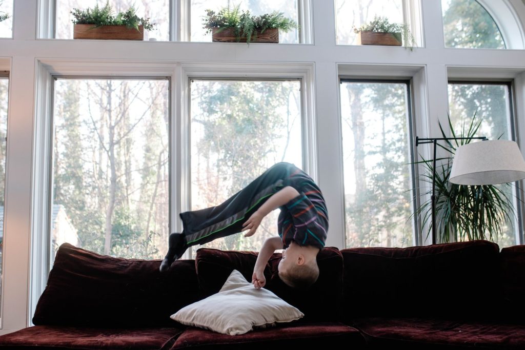 boy upside down as he is flipping onto a couch