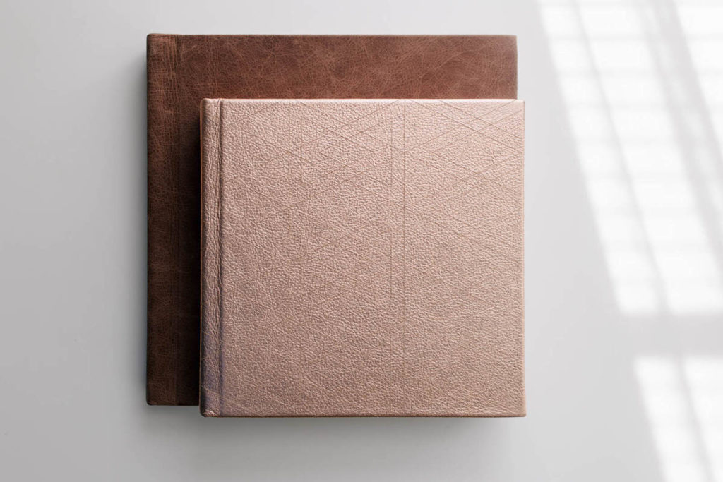 a pink album stacked on top of a brown album