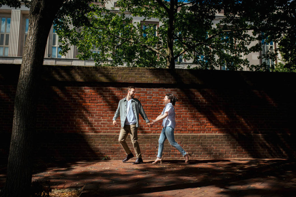 man looking back at woman as they hold hands and walk