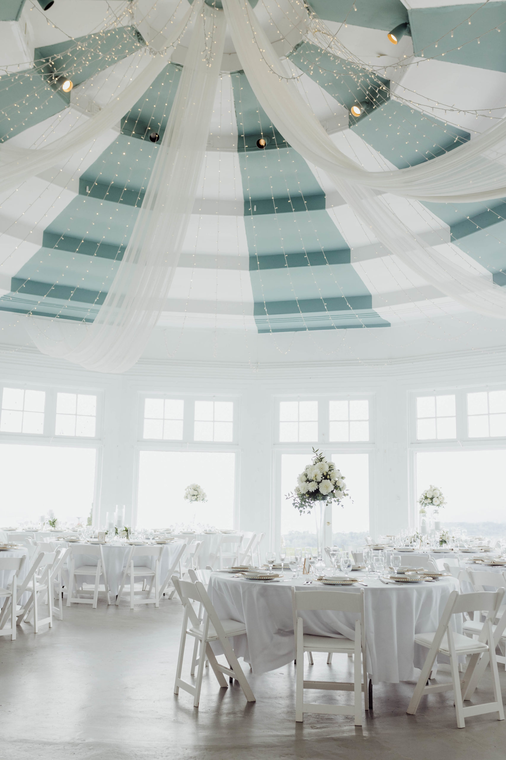 reception hall with circular white tables and chairs 