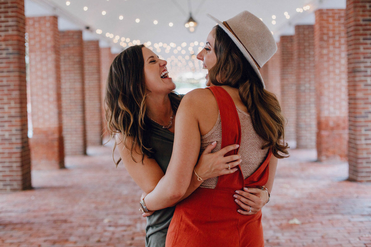 best places for engagement photos in Philadelphia two women hugging and laughing while looking at each other