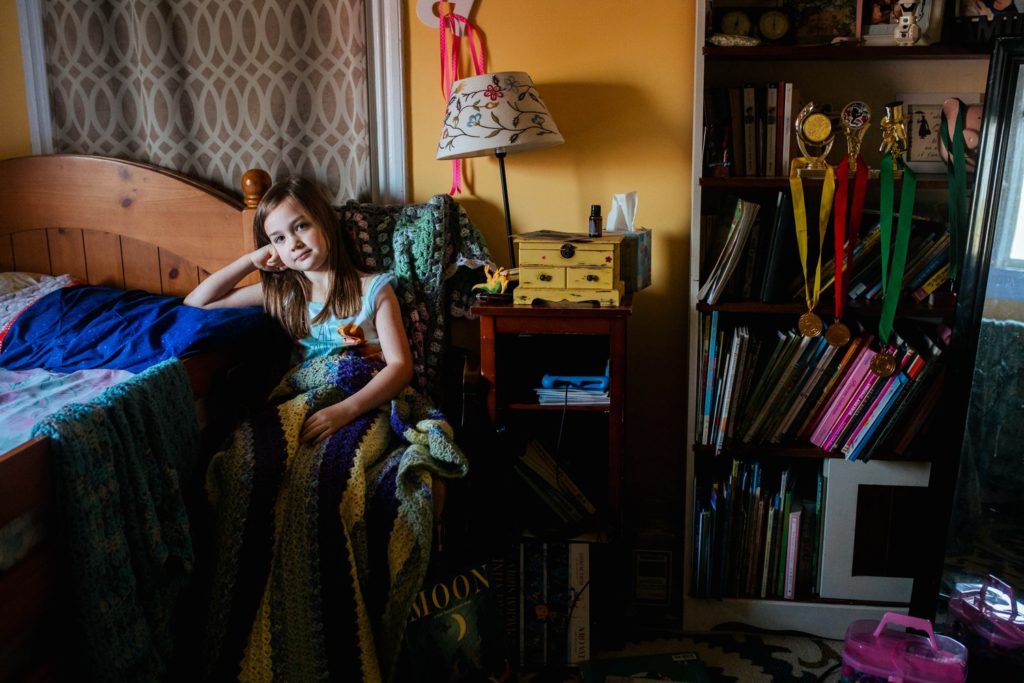 young girl sitting in a chair in her bedroom