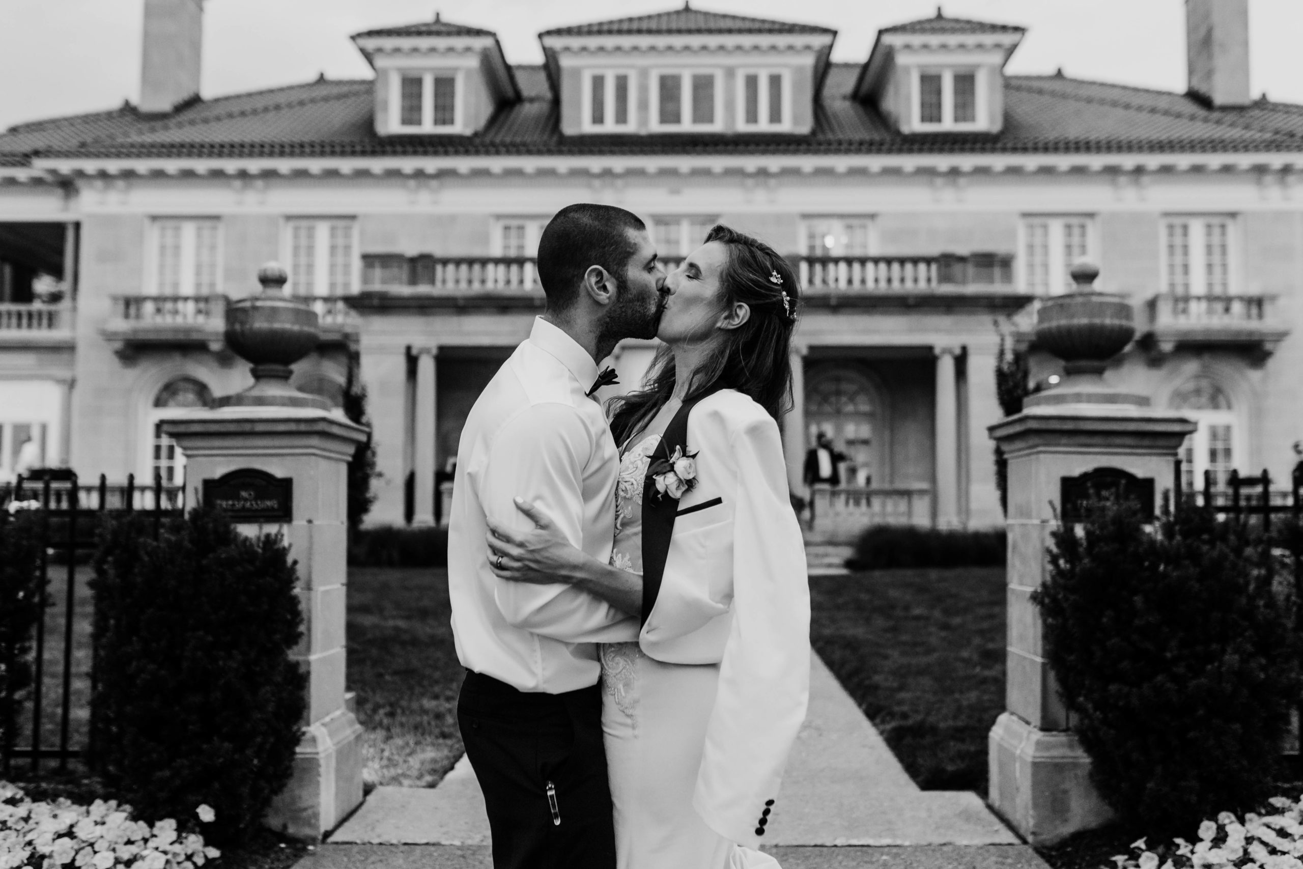 bride and groom kissing in front of a large building 