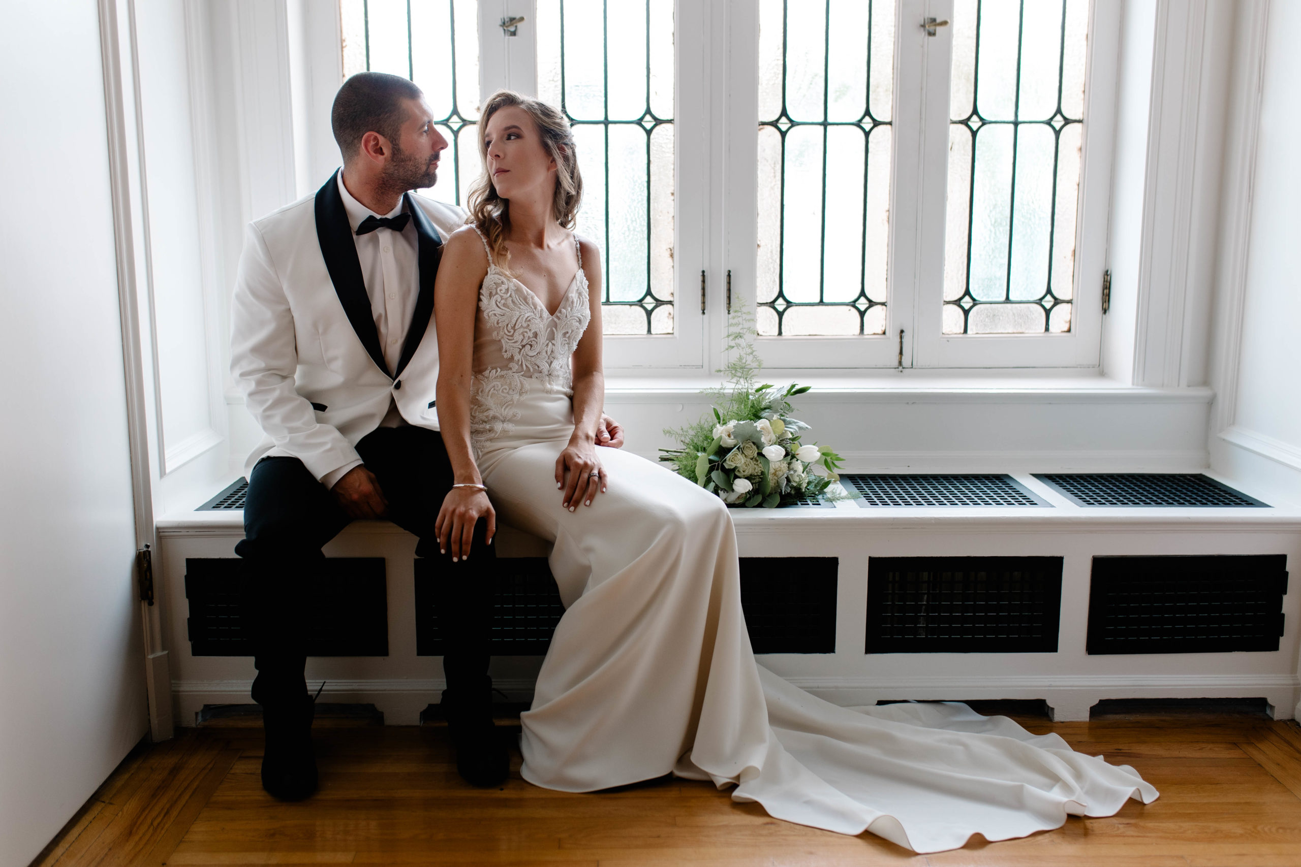 bride and groom sitting next to each other looking at each other 