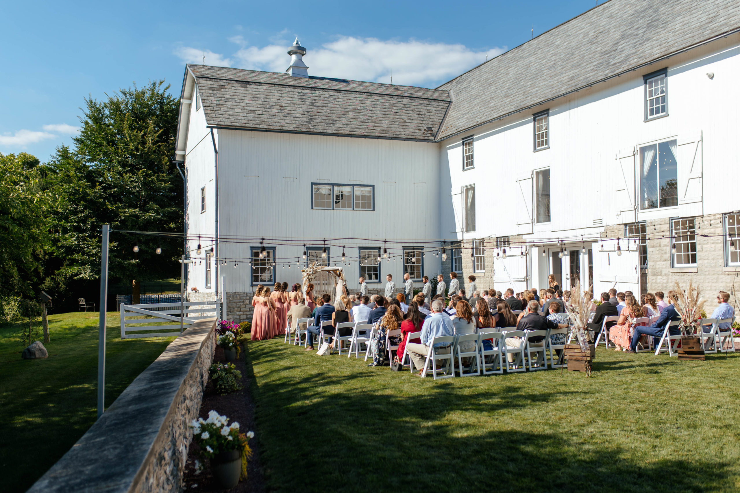 guests sitting in chairs outside of a large white building 