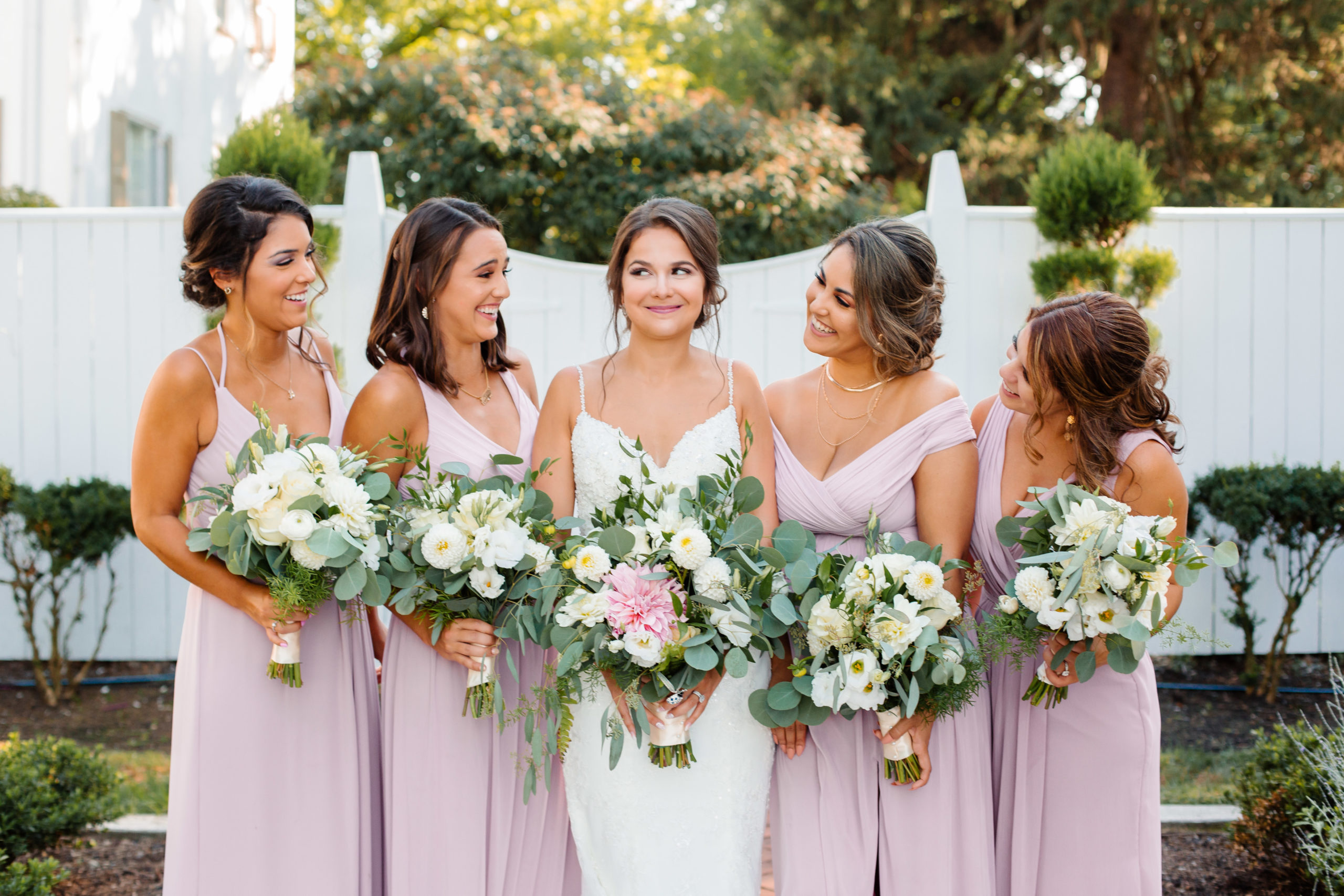 bride holding bouquet with bridesmaids standing next to her