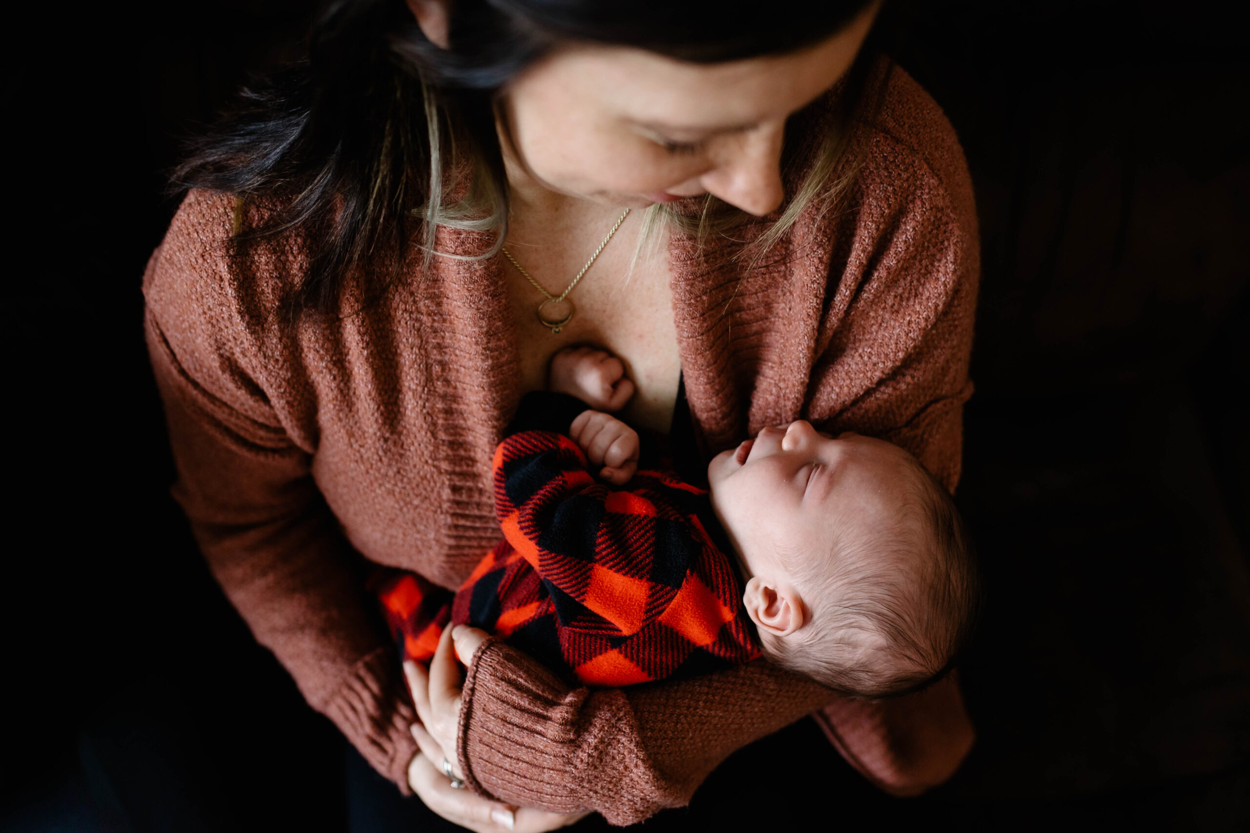 Mom holds newborn baby at home photography